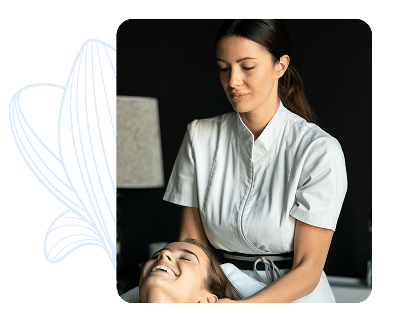 Esteticista realizando un masaje facial a una mujer relajada mientras sonríe, en un ambiente profesional y tranquilo.