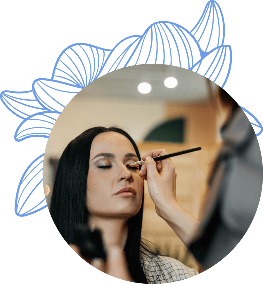 Maquilladora aplicando sombra de ojos a una clienta, destacando los servicios de belleza del centro.