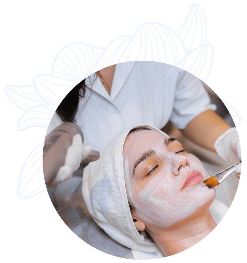 Mujer recibiendo un tratamiento facial en una clínica de estética, con una mascarilla aplicándose en su rostro por una profesional.