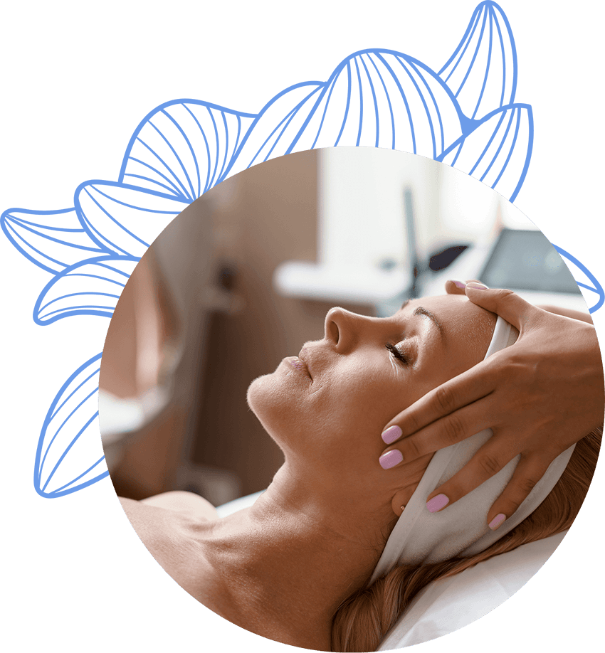 Esteticista realizando un tratamiento facial en una clienta, aplicando un masaje relajante en su cabeza mientras la clienta disfruta del tratamiento en un ambiente tranquilo.