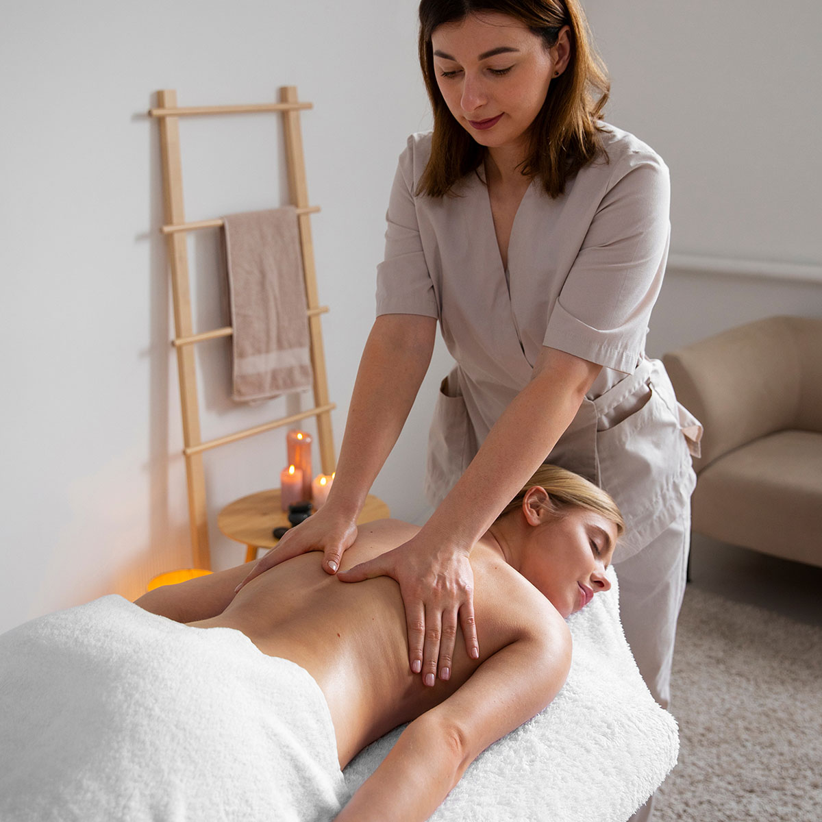 Terapeuta realizando un masaje en la espalda de una clienta, mostrando los servicios de relajación y bienestar del centro.